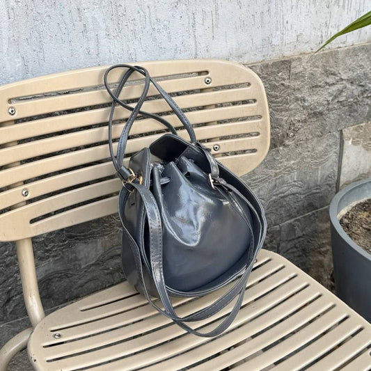 Gray leather bucket bag with drawstring closure